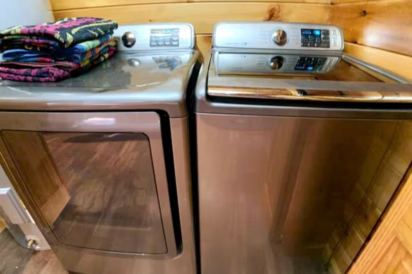 A washer and dryer with folded towels stacked on top.
